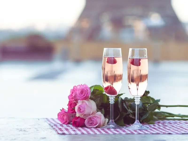Two glasses of wine and a bouquet of roses.